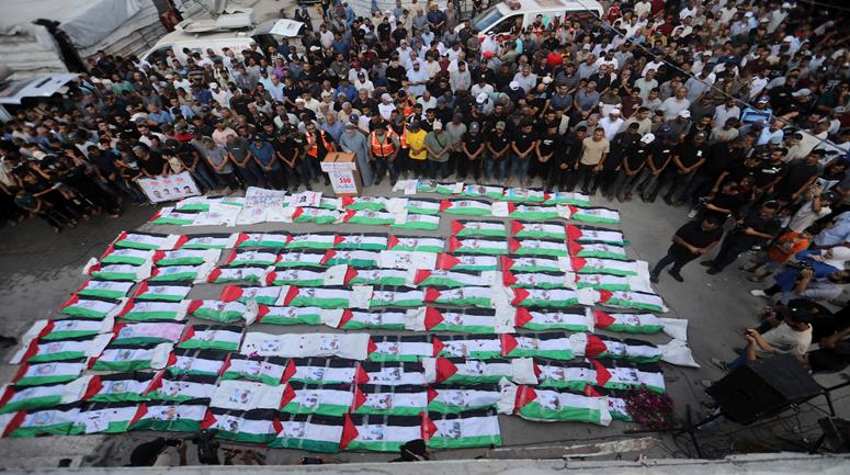 تشييع جثامين مئة شهيد في مقبرة الشهداء بحي الزيتون جنوب شرق مدينة غزة عقب انتشالهم من تحت ركام منازل في الحي