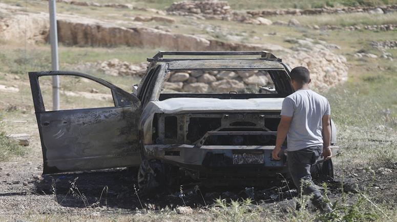 مواطنون  يتفقدون مركبة أُحرقها المستعمرون في واد الرخيم قرب بلدة يطا جنوب الخليل