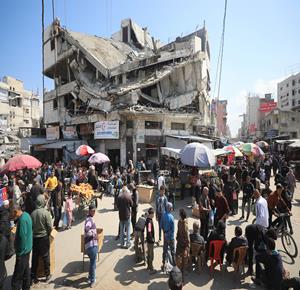 مواطنون يتجولون في سوق الزاوية بمدينة غزة خلال شهر رمضان بعد أن تضرر السوق بشدة خلال الحرب