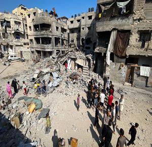 مواطنون يتفقدون الدمار الذي خلفته غارة جوية إسرائيلية استهدفت منازل المواطنين في مدينة غزة