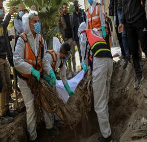 انتشال جثامين شهداء من قبور مؤقتة داخل المستشفى المعمداني في مدينة غزة لإعادة دفنها في مقبرة