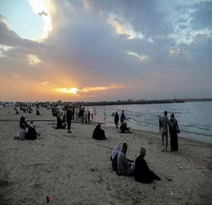 نازحون يقضون وقتهم على الشاطئ مقابل خيامهم الممتدة على طول ميناء غزة