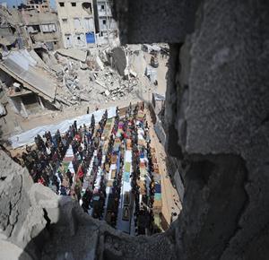 مواطنون يؤدون صلاة الجمعة الثالثة من شهر رمضان بين أنقاض مسجد صلاح الدين الذي دُمّر جراء الغارات الإسرائيلية خلال الحرب، في حي الزيتون بمدينة غزة