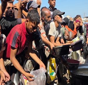 نازحون يتلقون وجبات غذائية من إحدى التكيات في منطقة مواصي خان يونس جنوبي قطاع غزة