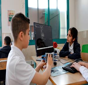 طلاب اثناء تعلمهم استخدام الذكاء الاصطناعي في العمليات الحسابية والتحكم في "روبوت" آلي