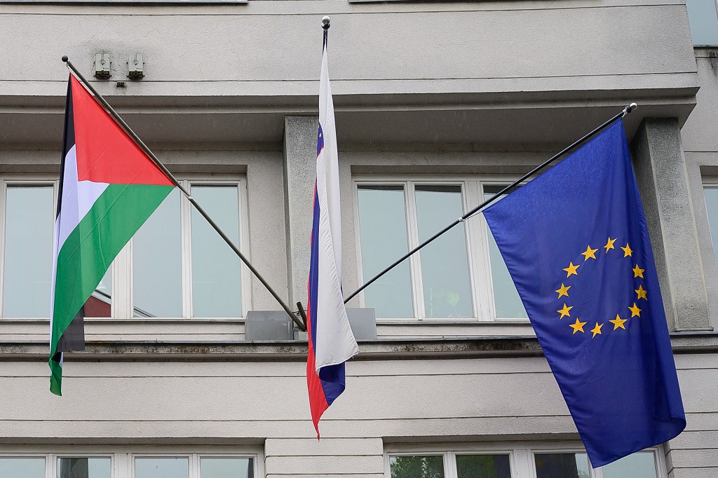 العلم الفلسطيني إلى جانب علمي سلوفينيا والاتحاد الأوروبي على المبنى الحكومي بالعاصمة ليوبليانا (أ ف ب)