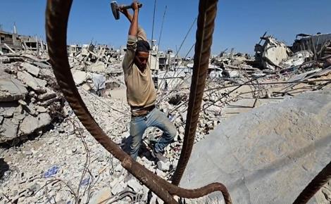 عمال يبحثون عن لقمة العيش تحت الأنقاض